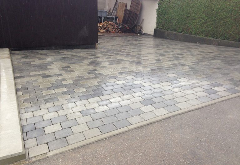 Hoffläche aus Pflastersteinen in unterschiedlichen Grau- und Beigetönen.