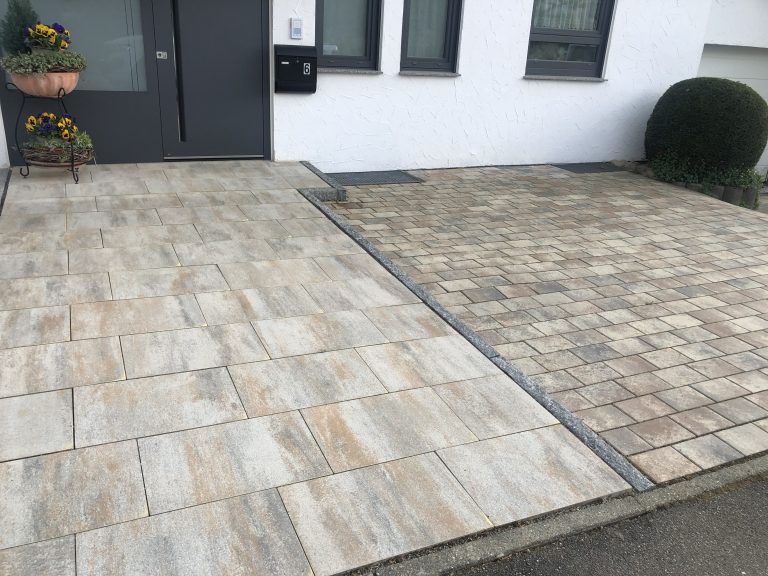 Kombination aus großformatigen Terrassenplatten und kleinteiligem Pflaster am Hauseingang.