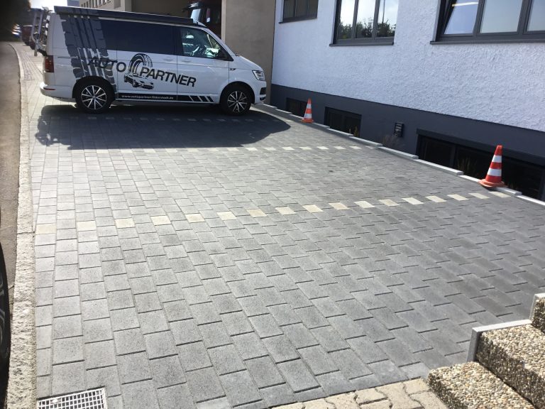 Große neu gepflasterte Hoffläche vor einem Wohnhaus.