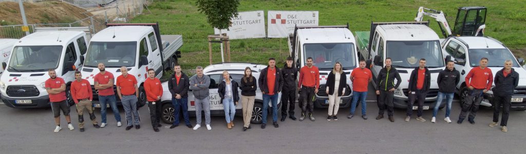Das Team von D&E Stuttgart vor den Firmenfahrzeugen